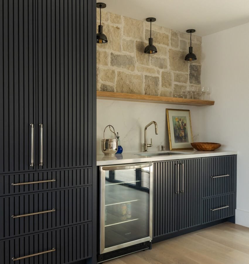 Wet bar with wine fridge and stone accent wall