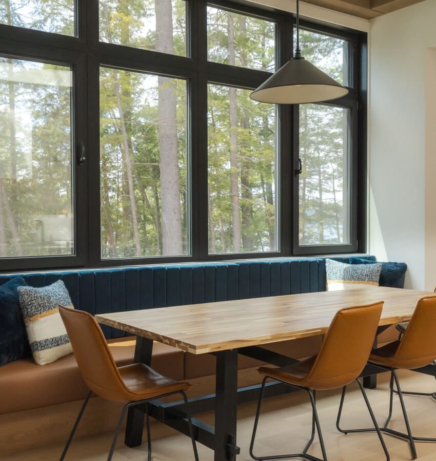 Dining nook with built-in bench seating and forest view